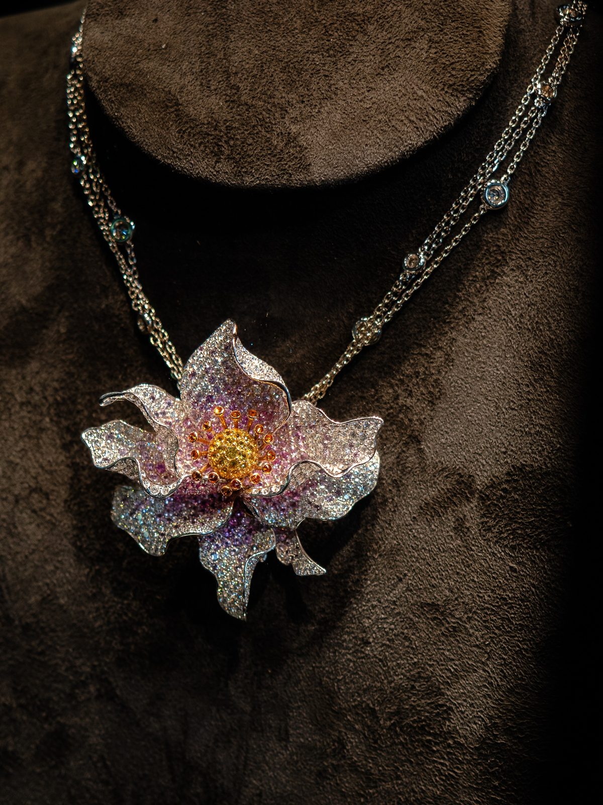A flower pendant necklace set with pink and white stones